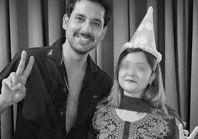"A man and a woman wearing a birthday party hat smiling and showing peace signs in a black and white photo"