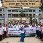 This is a news story illustration from the Bengali daily newspaper 'Prothom Alo'. It shows a large protest of primary school teachers and staff outside a Bangladeshi school building. A large wooden banner above the crowd features the newspaper's logo and the primary headline in Bengali: "Teachers' grouping and legal cases disrupt primary education, 34,000 headmaster posts vacant." It also lists the reporter "Golam Rabbani" and date "June 20, 2026." Teachers hold banners demanding resolutions, including a central one that reads, "Solve primary education crisis, fill 34,000 headmaster positions immediately!" Smaller signs read "Stop politics" and "Justice." Students watch from school windows.
