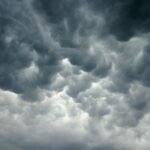 আকাশে মেঘ জমে বৃষ্টির সম্ভাবনা, ছাতা হাতে মানুষ