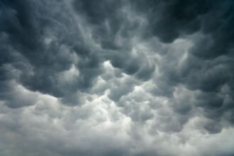 আকাশে মেঘ জমে বৃষ্টির সম্ভাবনা, ছাতা হাতে মানুষ